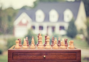 Buying real estate strategy chess game with house background
