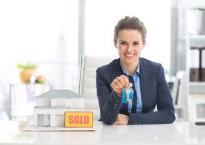 Happy realtor woman showing keys