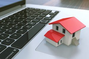 Small house on laptop keyboard. Real estate agency online. Concept. 3d illustration